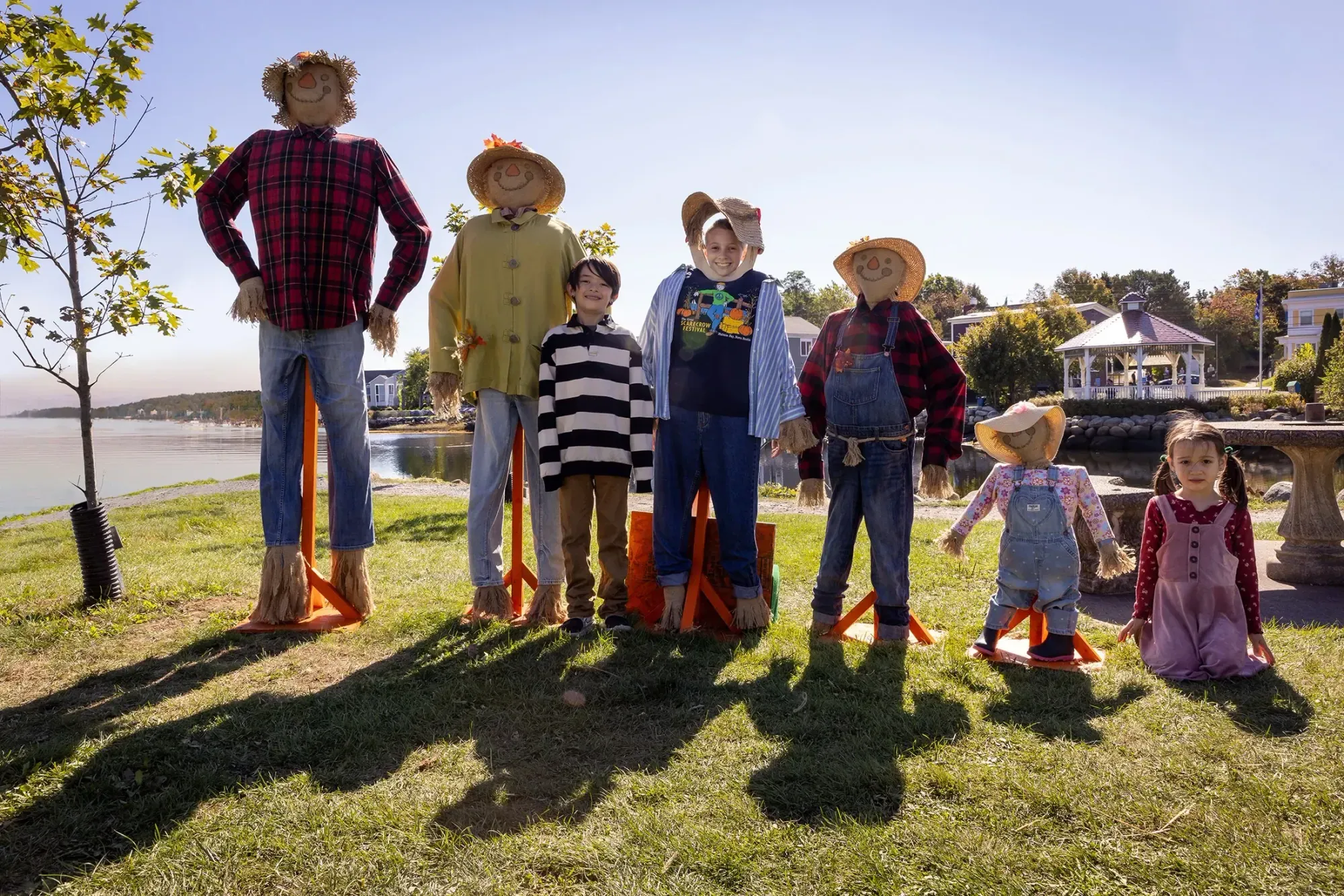 Children pose among a family of handmade scarecrows on the Mahone Bay waterfront during the Scarecrow Festival